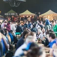 Street Food Festival in Aachen mit zahlreichen Menschen, die an verschiedenen bunten Essensständen zusammenkommen.
