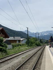IMG_7708.jpg Bahngleise mit Oberleitungen, linker Hand Häuser und in weiter Ferne das Wettersteinmassiv