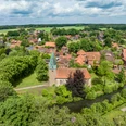 Bippen in der Samtgemeinde Fürstenau Luftaufnahme einer niedersächsischen Stadt mit Kirche, umgeben von Bäumen und Feldern.