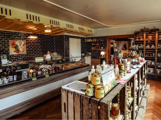 Degenhof_Manufaktur.jpg Der Verkaufsraum der Degenhof-Manufaktur in Egestorf zeigt eine einladende Atmosphäre mit reichlich ausgestellten regionalen Produkten und einer warmen, rustikalen Einrichtung.