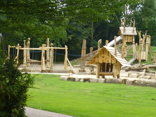 Bürgerpark Großer Holzspielplatz mit Rutschen, Schaukeln und Kletterelementen im grünen Bürgerpark Lengerich.