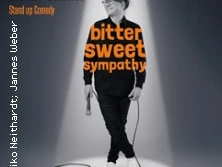 Thomas Schmidt steht im Scheinwerferlicht mit Mikrofon in der Hand, bereit für Stand-up Comedy.