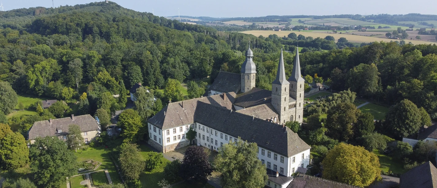 Luftbild Abtei Marienmünster Luftaufnahme der Abtei Marienmünster, umgeben von üppiger Natur und dichten Wäldern im Sommer.