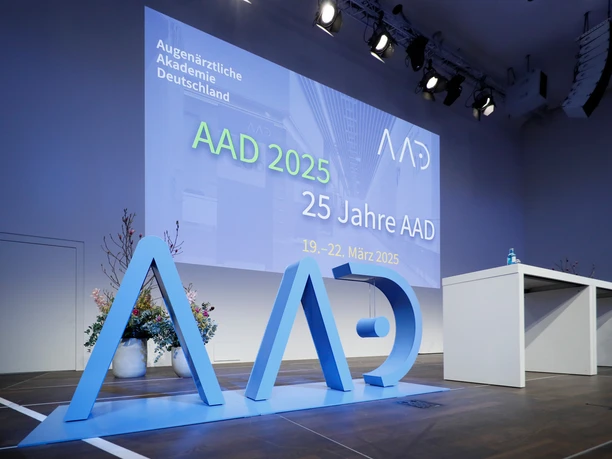 AAD 2024 AAD 2025 conference room with stage, decorated with a modern AAD logo in large blue letters.