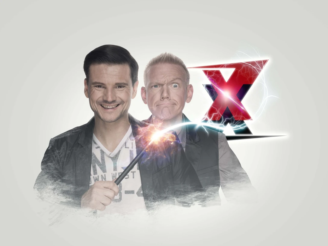 Zaubertrixxer Jung und Thomaszauberer mit Funkenstab, hinter ihm ein großes rotes X, beide lächeln.Young and Thomas Wizard with sparking staff, behind him a big red X, both smiling.
