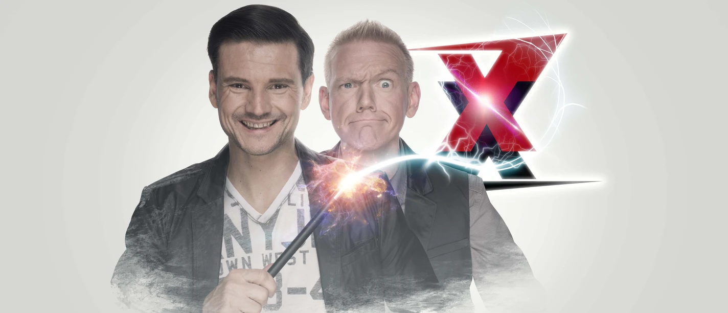 Zaubertrixxer Young and Thomas Wizard with sparking staff, behind him a big red X, both smiling.