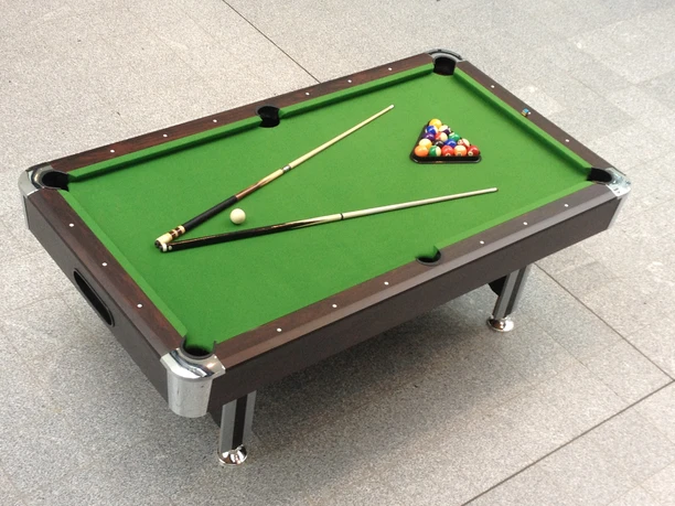 Billardtisch 01 Poolbillardtisch mit grünem Tuch, zwei Kös und arrangierten Kugeln in Startposition.