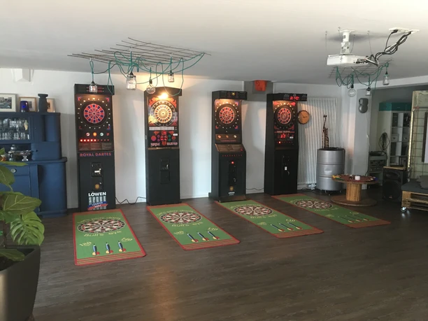 Turnier Dart-Gerät 01 Elektronische Dartscheiben in einem Raum mit Holzboden und Dekoration.
