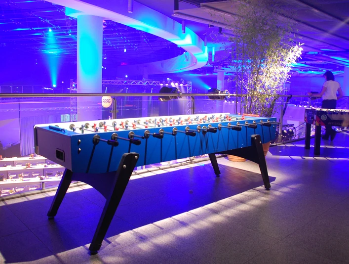 Riesentischkicker 01 Ein beleuchteter Tischfußballtisch in modernem, blauem Design in einer stimmungsvoll blauen Umgebung.An illuminated table football table in a modern, blue design in an atmospheric blue setting.
