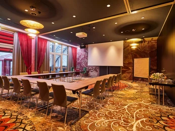 Attila, Gerasina U-Form.jpg <p>Tagungsraum mit U-förmiger Tischanordnung, Projektionsleinwand, Flipchart und eleganter Beleuchtung.</p><p>Meeting room with U-shaped table arrangement, projection screen, flipchart and elegant lighting.</p>