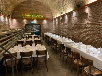 brauwelt-brauhaus-events-heiraten.jpg Ein festlich gedeckter Bankettsaal mit Ziegelgewölbe, beleuchtet von warmem Licht.A festively decorated banquet hall with a brick vault, illuminated by warm light.