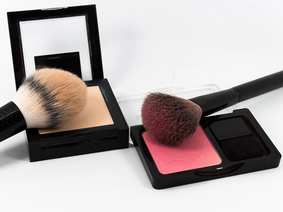 make-up Zwei Make-up-Pinsel und Puderdosen auf weißem Hintergrund.