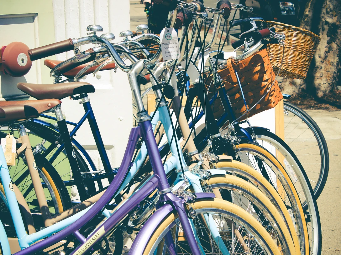 Radstation Bad Oeynhausen Mehrere bunte Fahrräder sind in einer Radstation abgestellt, ausgestattet mit Körben vorne.