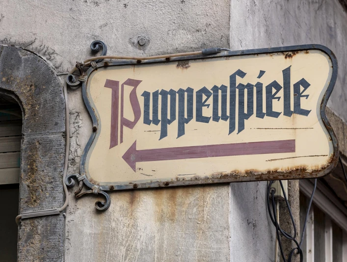Hänneschen Theater Schild mit "Puppenspiele", an einer Gebäudewand angebracht.