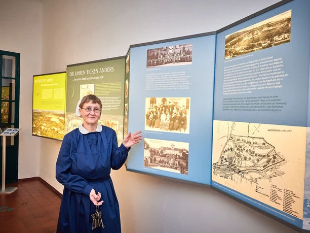 A guide in historical costume explains an informative exhibition on regional history.