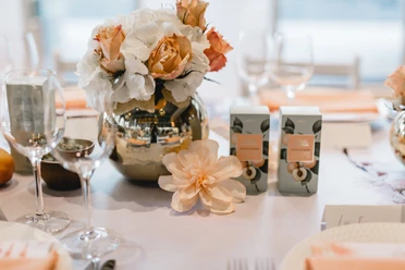 4711 Duftmenü Flower vase with roses and white flowers on an elegantly laid table, surrounded by wine glasses.