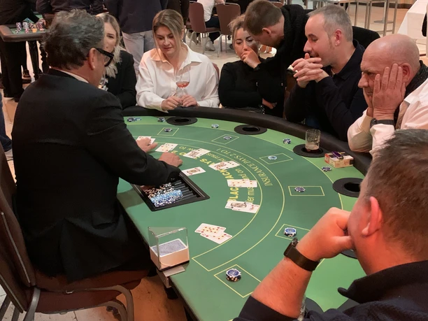 Black Jack 02 Poker table with people playing, cards and chips in a casino-like atmosphere.