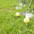 Crossgolf.jpg Golfschläger und Bälle auf grünem Rasen, bereit zum Abschlag.Golf clubs and balls on green grass, ready to tee off.