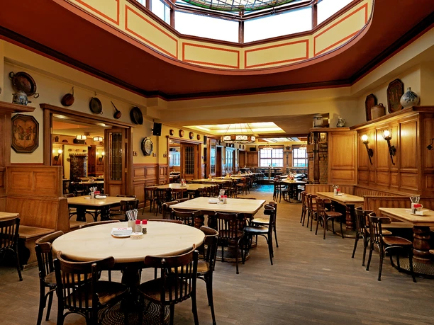 Brauhaus FRÜH am Dom, Wappesaal Ein traditionelles Wiener Gasthaus mit Holzvertäfelungen und gemütlicher Beleuchtung.