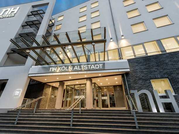 F_NH_k-ln-alstadt_112-7360x4912.jpg NH Hotel Köln Altstadt Eingang mit Treppe und Glasvordach bei Dämmerung.