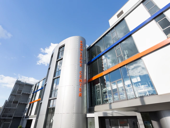 GS1 Germany GmbH - Knowledge Center Moderne Fassade eines Gebäudes mit der Aufschrift "Knowledge Center" unter blauem Himmel.</p>Modern facade of a building with the inscription "Knowledge Center" under a blue sky.</p> <p