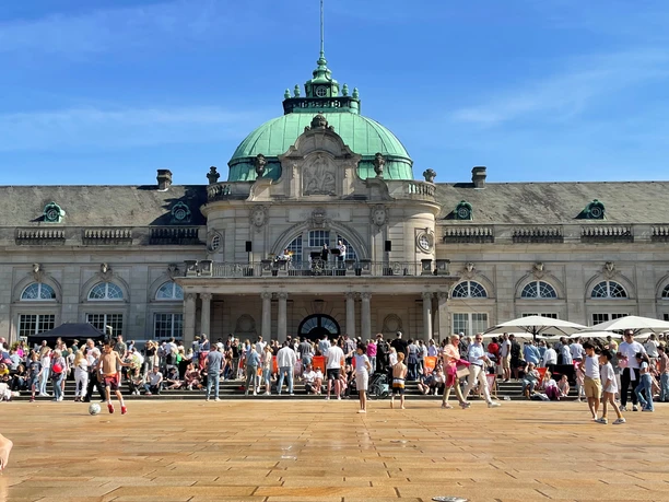 Tag der offenen Tür Vor dem Kaiserpalais in Bad Oeynhausen ist eine große Menschenmenge zu sehen. Die Besucher stehen in Gruppen vor den Ständen, während die Kinder auf der weitläufigen Kurhausterrasse spielen.
