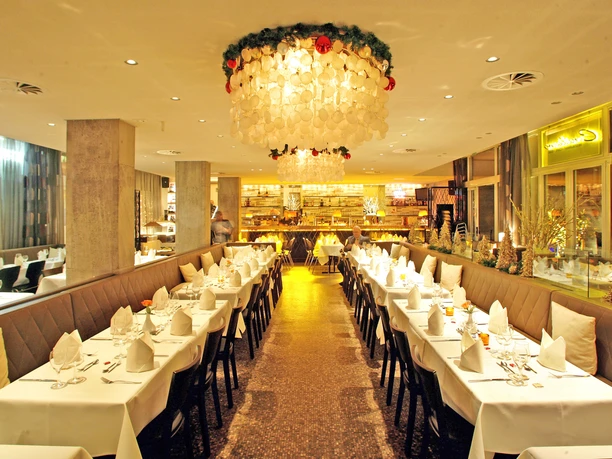 00-CONSILIUM-Event-Restaurant-Innenraum Elegantes Restaurant mit festlich gedeckten Tischen und strahlendem Kronleuchter in gemütlichem Ambiente.</p>
