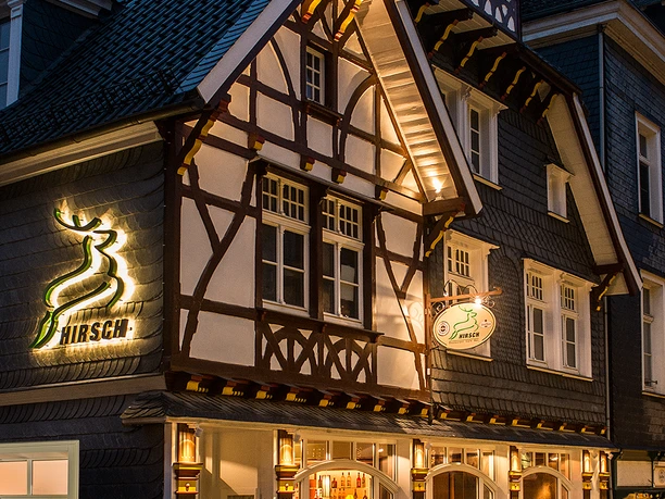 Hirsch Restaurant_Fassade.jpg Fachwerkhaus mit beleuchteter Fassade, Restaurant "Hirsch", traditionelle Elemente, abends aufgenommen.