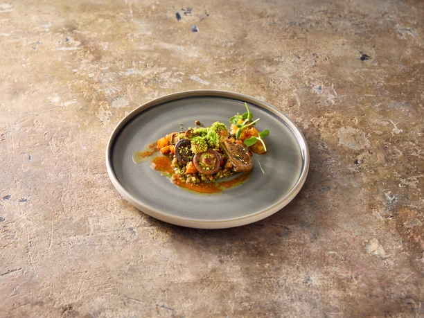 Food1 Elegant dish of veal, vegetables and green herbs on a gray, rustic table.</p> <p