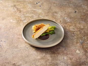 Food2 Gebratenes Hähnchenbrustfilet mit knuspriger Kruste, serviert auf Wirsingblatt und Sauce auf grauem Teller.Fried chicken breast fillet with a crispy crust, served on a savoy cabbage leaf and sauce on a gray plate.