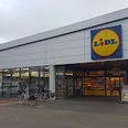 Lidl_Augustfehn_2023.jpg Ein moderner Lidl-Supermarkt mit großem Parkplatz, Fahrradständern, klarer Architektur und dem markanten, blau-gelben Logo.