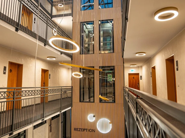 Modernes Atrium im CityHome Boardinghouse mit Glasdach, Galerien und Rezeption