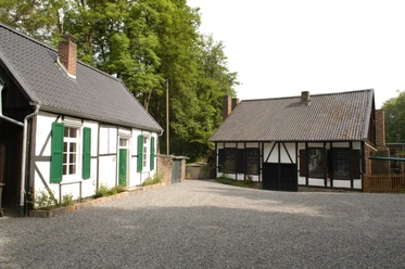 Mühlentag Zwei historische Fachwerkhäuser mit Schieferdächern und grünen Fensterläden, umgeben von Bäumen.