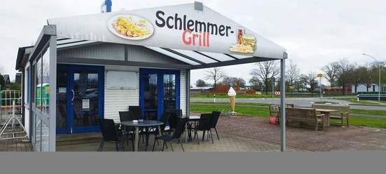 Kleiner Imbiss mit überdachtem Außenbereich, blauen Türen und Sitzplätzen an einer Straßenecke.