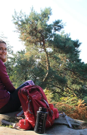 Ibbenbüren_Plisseefelsen_Stadtmarketing Ibbenbüren GmbH_SPL_2000.jpg Zwei Personen sitzen entspannt auf einem Felsen, umgeben von grünen Bäumen und genießen den Ausblick.