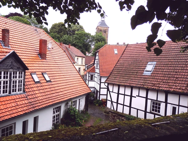 Tecklenburg_Teutoburger Wald Tourismus_I Bohlken.jpg Fachwerkhäuser mit roten Dächern in Tecklenburg, im Hintergrund ein Kirchturm und viel Grün.