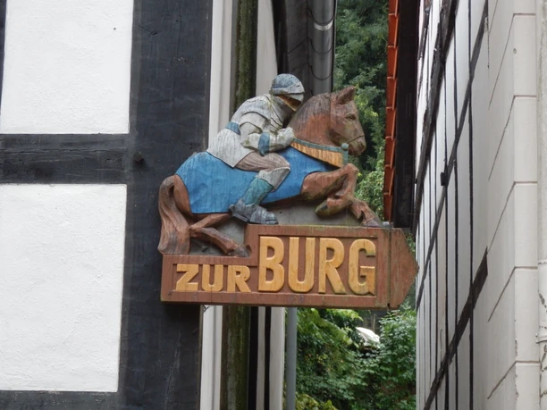 P7290038.JPG Holzschild einer historischen Gaststätte zeigt einen Ritter auf einem Pferd mit dem Schriftzug "Zur Burg".