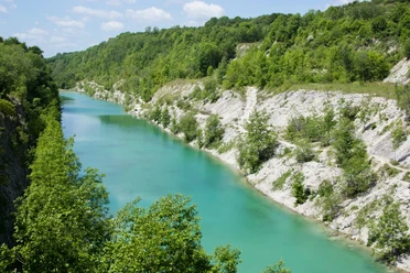 Canyon© Tecklenburger Land Tourismus e.V. - Rudi Schubert.JPG Blick auf eine türkisfarbene Schlucht, umgeben von grünen bewaldeten Hügeln unter blauem Himmel.