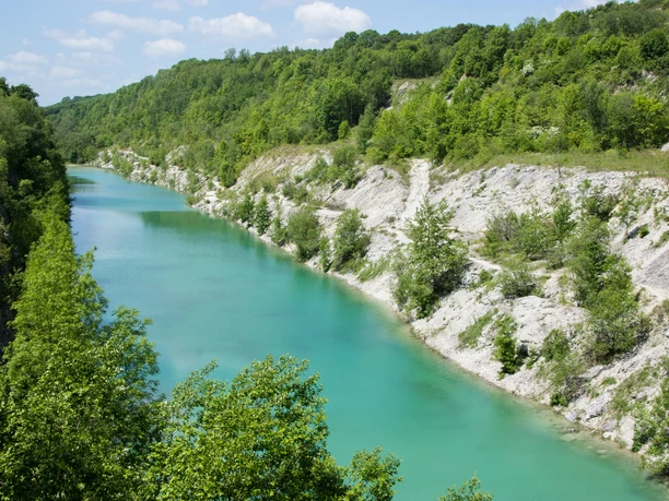 Canyon© Tecklenburger Land Tourismus e.V. - Rudi Schubert.JPG Blick auf eine türkisfarbene Schlucht, umgeben von grünen bewaldeten Hügeln unter blauem Himmel.