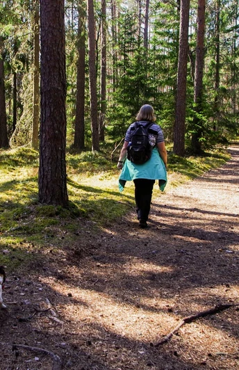 Bad Driburg_Wandern_pexels-pille-kirsi.jpg Eine Frau wandert mit ihrem Hund an Reelsen entlang.