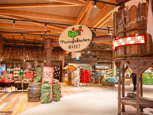 Interior view of a market with handmade products and rustic wooden decorations.