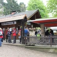 Eine Gruppe Wanderer versammelt sich vor einer Almhütte mit Biergarten im Teutoburger Wald.