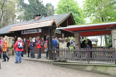 Dörenther Klippen_Almhütte_Teutoburger Wald Tourismus.JPG Eine Gruppe Wanderer versammelt sich vor einer Almhütte mit Biergarten im Teutoburger Wald.