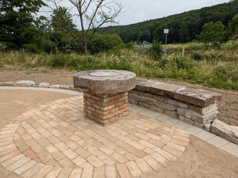 Aussichtspunkt Gellinghausen Steinplattform mit Sitzbank vor grüner Landschaft. Optimaler Blick über die umliegende Natur.