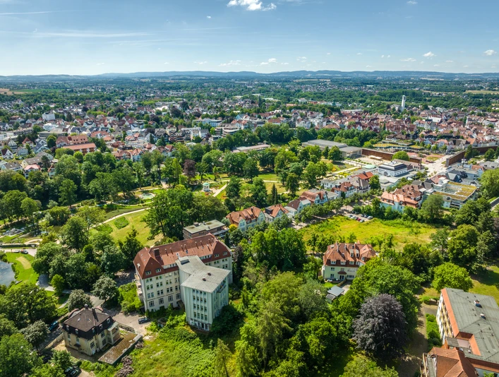 Luftaufnahme des Kurparks Bad Salzuflen: grüne Oase mit Gehwegen und historischen Gebäuden umgeben.