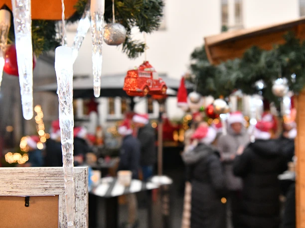 Weihnachtsmarkt feeling Verschneiter Weihnachtsmarkt mit geschmückten Ständen, Lichterketten und Menschen in Winterkleidung.</p>