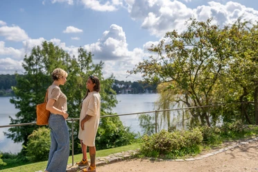 Blick auf den Domsee in Ratzeburg Zwei Frauen stehen am Ufer des Domsees in Ratzeburg und genießen das sommerliche Wetter.