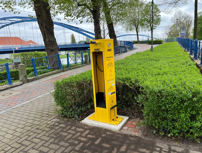 ADAC-Radservicestation Fahrradservicestation des ADAC am Radweg, ausgestattet mit Werkzeug und Luftpumpe in einer grünen Umgebung.