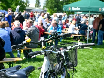 Fahrradfrühling, Mülheim an der Ruhr Zwei Fahrräder im Vordergrund, im Hintergrund: Menschen bei einem Frühlingsfest im MüGa-Park.