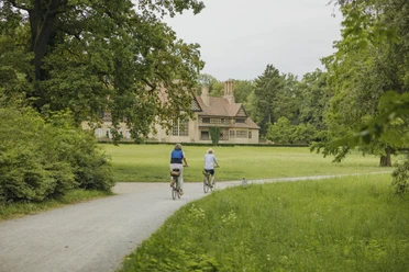 Schloss Cecilienhof im Neuen Garten Radfahrende im Neuen Garten am Schloss Cecilienhof im Sommer